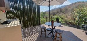 a patio with a table and chairs and an umbrella at Casa Catonalco in Xalmolonco