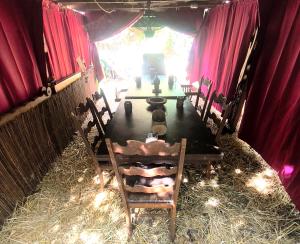 a table and chairs in a room with red curtains at Le Camp du Chevalier, hébergement insolite près du zoo de Beauval et des châteaux de la Loire in Valençay +22 photos