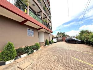 a building with a car parked in a parking lot at The Reset Stay in Kampala