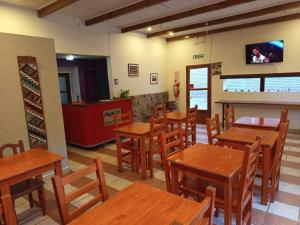 a restaurant with wooden tables and chairs and a tv at Hotel Munay La Quiaca in La Quiaca