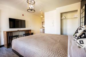 a bedroom with a bed and a flat screen tv at Tolleson Studio Pool & Gym Access for 2 in Tolleson