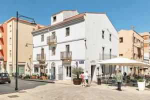 a group of people standing outside of a white building at Gaias Rooms in Olbia