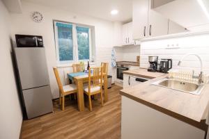a kitchen with white cabinets and a table and chairs at Tarján Gyöngye in Salgótarján