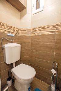 a bathroom with a toilet and wooden walls at Tarján Gyöngye in Salgótarján +10 photos