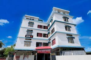 a tall white building with a sign in front of it at SPOT ON S.D.S GUEST HOUSE in Guwahati +21 photos