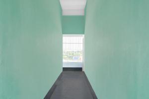 a hallway with a blue wall and a window at SPOT ON S.D.S GUEST HOUSE in Guwahati