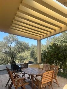 a patio with a wooden table and chairs on a patio at Villa Elli in Limenas