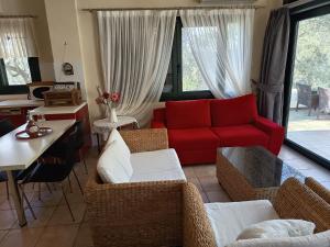 a living room with a red couch and chairs at Villa Elli in Limenas