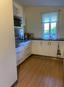 a kitchen with white cabinets and a wooden floor at The Haven in Blackall