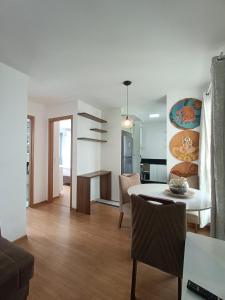 a living room with a table and a dining room at Acomodações Azaleias by Rental in Palhoça