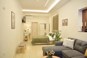 ein Wohnzimmer mit Sofa und Bett in der Unterkunft Chatzidakeio View Apartments in Xánthi + 14 Fotos