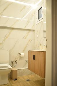 ein Badezimmer mit weißen Marmorwänden und einer Toilette in der Unterkunft Chatzidakeio View Apartments in Xánthi