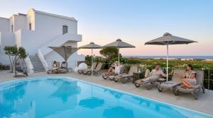 a group of people sitting around a swimming pool at DL Santorini in Monolithos