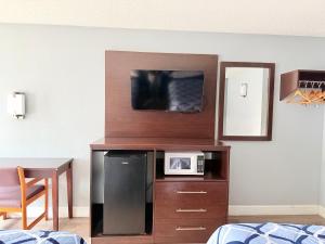 a room with a microwave and a tv on a cabinet at Knights Inn Ruther Glen in Ruther Glen