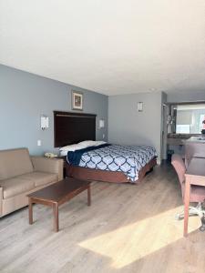 a bedroom with a bed and a couch and a table at Knights Inn Ruther Glen in Ruther Glen