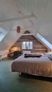 a bedroom with a large bed in a attic at Koppes Mølle B&B - naturnær overnatning in Borup