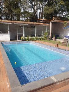 a swimming pool in front of a house at Hostel e Camping Yoshida Naturismus in Ibiúna