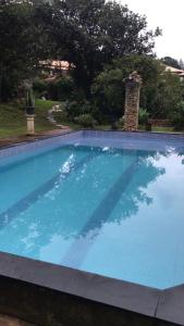 a large swimming pool with blue water at Hostel e Camping Yoshida Naturismus in Ibiúna
