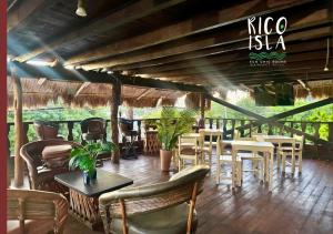 a restaurant with tables and chairs on a patio at Rico Isla Rooms Eco-Chic in Isla Mujeres