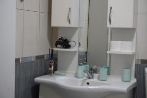 a bathroom with a sink and a mirror at Prishtina Center Apartment, 100m from Skanderbeg Square in Prishtinë +14 photos