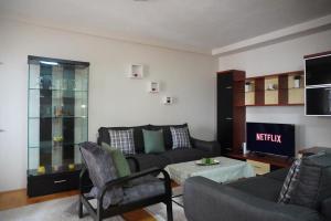 a living room with a couch and a table at Prishtina Center Apartment, 100m from Skanderbeg Square in Prishtinë