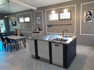 a kitchen with a sink and a table with chairs at Gala Da Vittoria in Capelas
