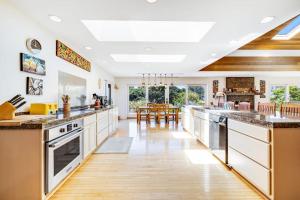 a large kitchen with white cabinets and wooden floors at Voyagers Paradise in Gualala
