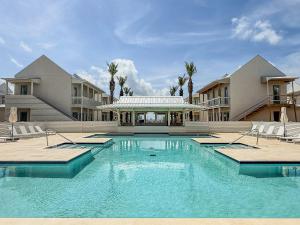 a large swimming pool in front of a building at The Pass Bungalows in Pass Christian