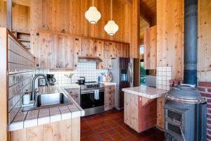 a kitchen with wooden walls and a stove top oven at Breakers Hideaway in Sea Ranch
