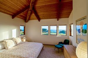 a bedroom with a bed and a desk and windows at Breakers Hideaway in Sea Ranch