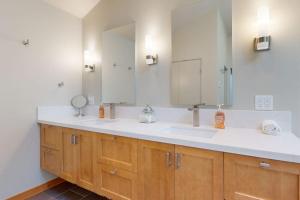 a bathroom with two sinks and a large mirror at West Meadow in Sea Ranch