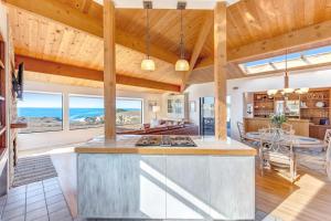 a kitchen and living room with wood ceilings and a table at Del Mar Point in Sea Ranch