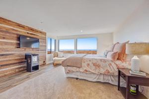 a bedroom with a large bed and a wall with windows at Del Mar Point in Sea Ranch