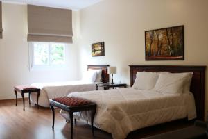 a bedroom with two beds and a window at Villa São Carlos in Caxias do Sul +9 photos