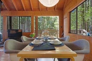 a dining room with a table and chairs and windows at Cabin 55 in Sea Ranch
