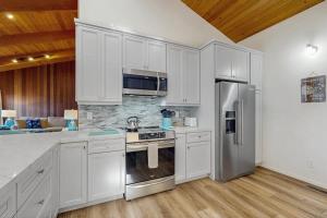 a kitchen with white cabinets and stainless steel appliances at Sea Raven in Gualala