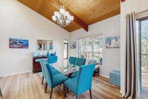 a dining room with a glass table and blue chairs at Sea Raven in Gualala +24 photos
