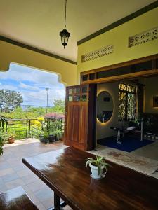 a living room with a wooden table and a balcony at Aivilo Home in Entebbe