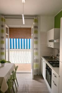 a kitchen with a table and a dining room with a window at Il Mare a Pochi Passi in Marina di Ragusa