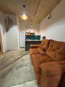 a living room with a brown couch in a room at Casa natureza Paraty I in Paraty