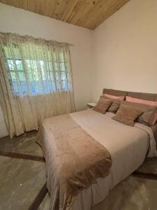 a bedroom with a large bed and a window at Casa natureza Paraty I in Paraty