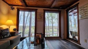 a living room with a couch and two large windows at Beaver Creek Hideaway in Kenai