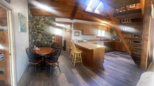a kitchen with a wooden table and a wooden floor at Beaver Creek Hideaway in Kenai +18 photos