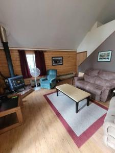 a living room with a couch and a table at Sterling Cabin close to Kenai River in Sterling