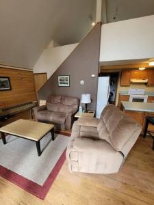 a living room with a couch and a table at Sterling Cabin close to Kenai River in Sterling