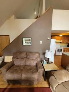 a living room with a couch and a chair at Sterling Cabin close to Kenai River in Sterling