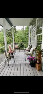 a porch with chairs and tables on a house at Constellation Lake Home in Kasilof
