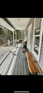a porch with a wooden bench on a house at Constellation Lake Home in Kasilof
