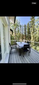 a patio with a table and benches on a porch at Constellation Lake Home in Kasilof