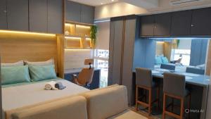 a bedroom with a bed and a desk with chairs at Apartamento Águas Claras S4 particular in Águas Claras